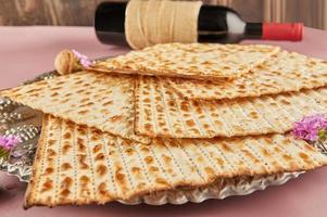 Pesach celebration concept - jewish Passover holiday. Matzah on Seder plate with bottle of red wine photo