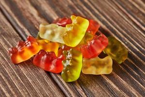 Multicolored bears gummy candy on wooden vintage background. Jelly candies of different colors photo