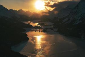 Colorful sunset over the frozen lakes of the Swiss alps at the Maloja pass photo