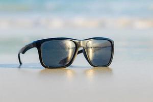 Sunglasses on sand beautiful summer beach  copy space Holiday concept. photo