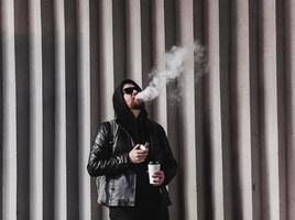cool bearded man smokes e-cigarettes photo