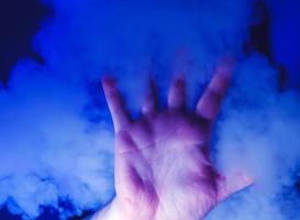 mano en humo azul foto