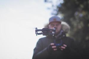 joven pilotando drone al aire libre foto