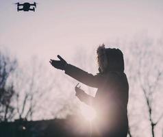 man with a flying drone at sunset photo