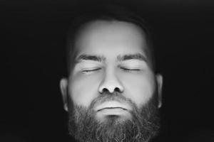 bearded man with closing eyes photo