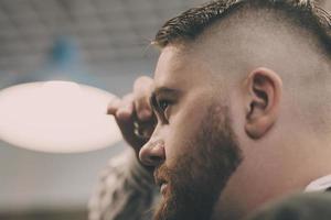 Hairdresser performs a fashionable haircut photo