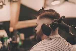 Hipster man getting haircut photo