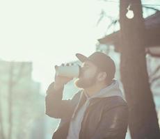 hombre con chaqueta de cuero bebiendo café foto