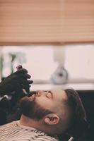 Barber shaving a bearded man photo