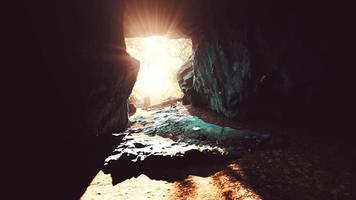impresionante paisaje de brillantes rayos de sol cayendo dentro de una cueva iluminando