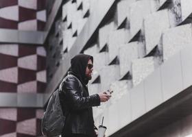 Fashion male dressed in leather jacket vaping. photo