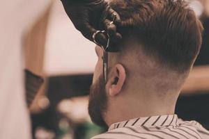 Brutal bearded man getting beard haircut photo