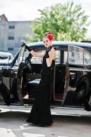 retrato de hermosa modelo de chica de moda morena sexy con maquillaje brillante en estilo retro cerca de coche vintage con un cigarrillo en la mano. foto