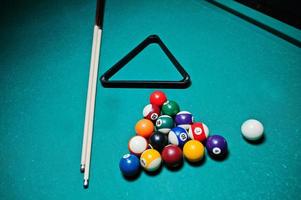 Billiard balls in a pool table at triangle with billiard cue photo