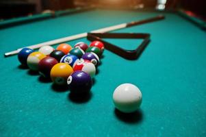 Billiard balls in a pool table at triangle with billiard cue photo
