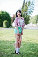 Portrait of style country girl on short green shorts and crosscountry checkered line shirt photo