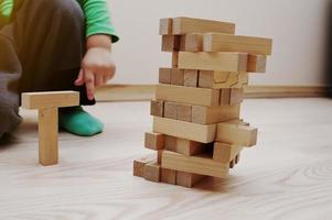 Hand of baby who played developmental game of wooden blocks lumber