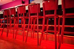 Red bar stools at diode color light photo