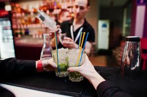 Waiter hands holding mojito coctails drink background bar man at work photo