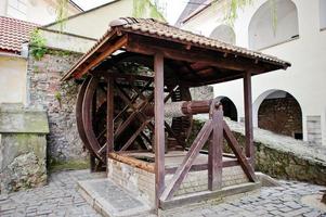 Old wooden water well with pulley and bucket. Palanok castle photo