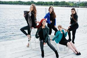 cinco hermosas modelos de chicas jóvenes en chaquetas de cuero posando en la litera. foto