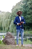 Full length portrait of stylish black man at jacket, hat and sunglasses photo