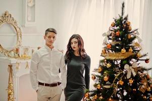 joven pareja elegante con regalos de navidad y decoración de año nuevo. tono de color suave y cálido. foto