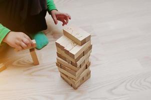 Hand of baby who played developmental game of wooden blocks lumber photo