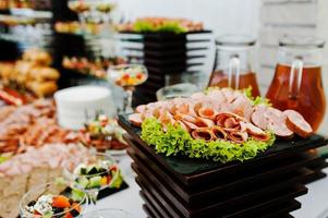 Buffet table of reception with burgers, cold snacks, meat and salads photo