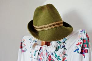 viejo sombrero de lino verde oliva en un maniquí con ropa tradicional foto