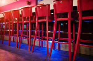 Red bar stools at diode color light photo