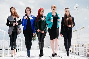 Five beautiful young girls models at leather jackets posing on berth. photo