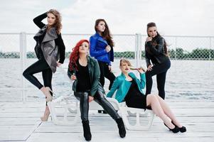Five beautiful young girls models at leather jackets posing on berth. photo