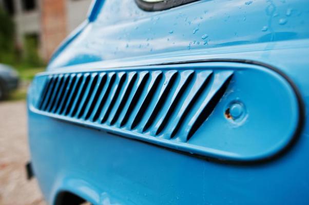 Diagonal louvred air vent on a metallic blue vintage retro car.