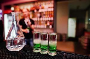 tres cócteles mexicanos verdes y barman de fondo de jarra en el bar foto