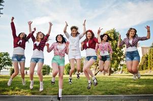 Seven happy and sexy girls on short shorts jumping and having fun at park on bachelorette party photo