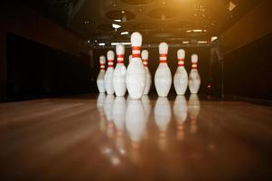 Ten white pins in a bowling alley lane photo