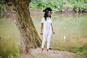 feliz hermosa chica afroamericana negra con sombrero graduados foto