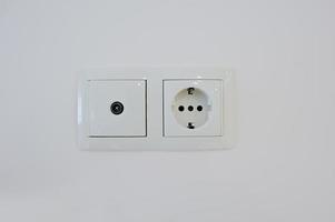 Twin electric socket with tv plug at the wall photo