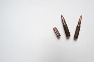 Three rifle and pistol bullets on white background photo