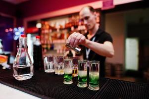 Barman preparing green mexican cocktail drink at the bar photo