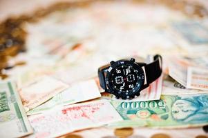 Black watch on money. Time is money concept photo