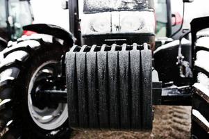 Close up in front of the new red tractor at snowy weather photo