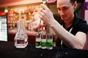 Barman preparing green mexican cocktail drink at the bar photo