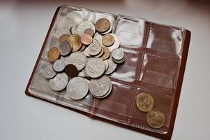 Different countries coins at umismatics album photo