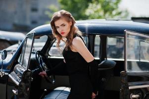 retrato de una hermosa modelo sexy de chica de moda con maquillaje brillante en estilo retro cerca de un auto antiguo