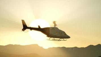 Helicóptero volador en cámara lenta extrema de 8k y cielo al atardecer video