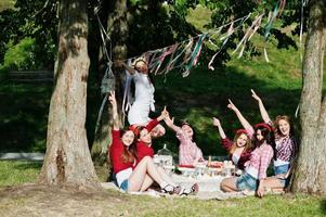 Happy and sexy girls sitting at picnic table and having fun on bachelorette party photo