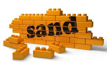 sand word on yellow brick wall photo
