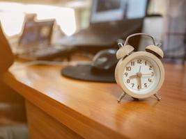 Close up small Alarm clock on the working desk in the office photo